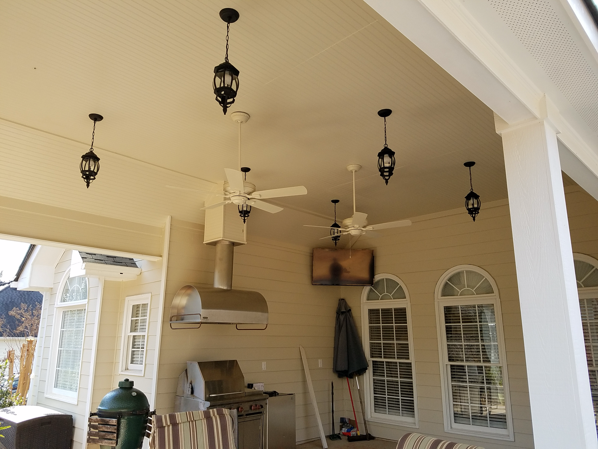 Outdoor kitchen with pendant lights and ceiling fans — Keystone South Construction